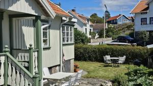 a house with a table and chairs in a yard at West Coast house 50m from the harbor in Edshultshall in Hälleviksstrand