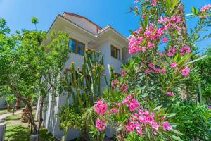 フェティエにあるDream of Oludeniz Hotel -All inclusiveの木々やピンクの花に囲まれた家