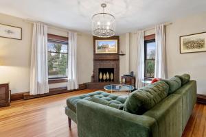 a living room with a green couch and a fireplace at Historic Queen Anne Family Home w Modern Comforts in Harpers Ferry +43 photos