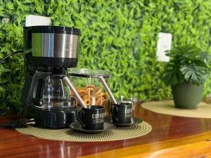 a coffee maker with two cups and donuts on a table at Casa com 2 quartos em Americana in Americana +22 photos