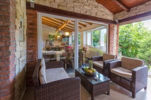 een patio met rieten stoelen en een tafel op een veranda bij Holiday home in Krizisce 40737 in Križišće