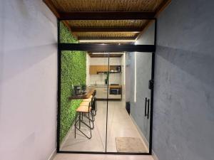 a kitchen with a green wall with stools in it at Casa com 2 quartos em Americana in Americana