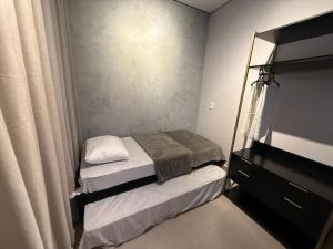 a small bedroom with two beds and a dresser at Casa com 2 quartos em Americana in Americana