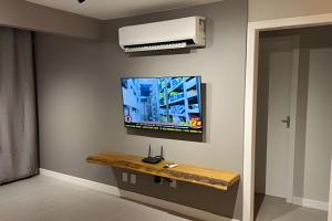 阿拉亚尔-杜卡布Todo reformado pertinho da praia的带电视和桌子的客厅