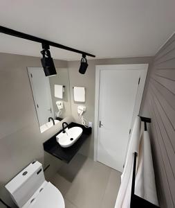 阿拉亚尔-杜卡布Todo reformado pertinho da praia的浴室里有马桶、洗手池和镜子。