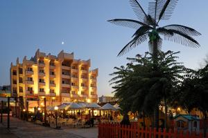 a hotel with a palm tree and tables and umbrellas at Hotel Life in Rimini