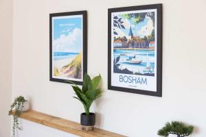 two framed posters on a wall in a living room at Homely Cottage for 6 Near Chichester & Goodwood in Chichester