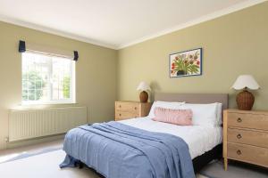 a bedroom with a bed with a pink pillow and a window at Homely Cottage for 6 Near Chichester & Goodwood in Chichester