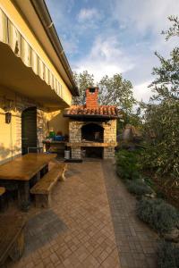 スタリグラードにあるApartments in Starigrad-Paklenica 6891の石造りの暖炉とベンチ付きの屋外パティオ