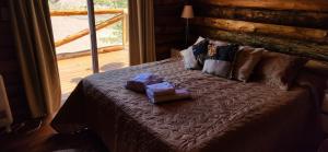 a bed in a log cabin with two boxes on it at Cabin by the Mendoza River in Potrerillos