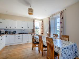 a kitchen and dining room with a table and chairs at Meadowgreen Farmhouse in Forfar
