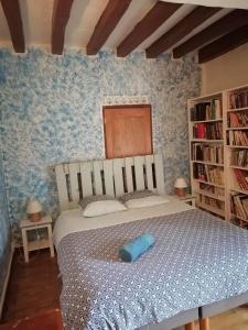 a bedroom with a bed with a blue pillow on it at Les Ecuries de Montdoucet in Souancé-au-Perche