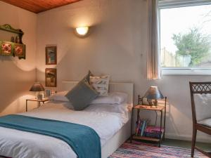 ein Schlafzimmer mit einem Bett und einem Fenster in der Unterkunft Timbers in Woolfardisworthy