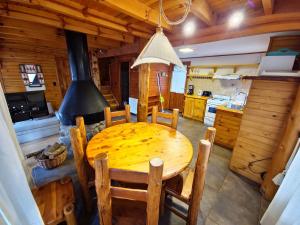 a wooden table and chairs in a kitchen with a stove at El Remanso - Arrayan Cabin, Bahía Manzano in Villa La Angostura