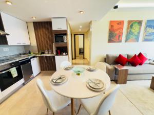 a kitchen and a living room with a table and chairs at Cosy Nest - Home cinema, Beach, Mall, TGV station, IPTV, WIFI, AC in Tangier