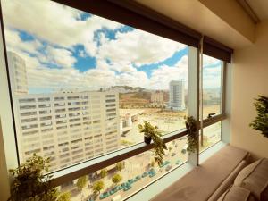 a large window with a view of a city at Cosy Nest - Home cinema, Beach, Mall, TGV station, IPTV, WIFI, AC in Tangier