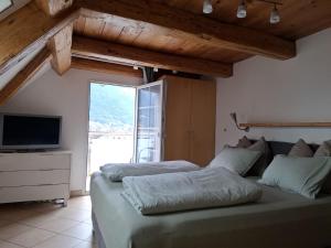 a bedroom with a bed and a tv and a window at Hotel & Restaurant Rössli in Seedorf