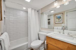a bathroom with a toilet and a sink and a tub at King and Prince #176 in Harrington +14 photos