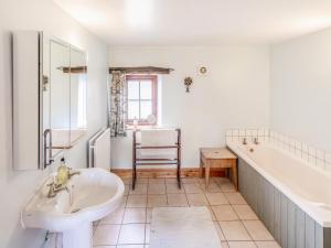 a bathroom with a tub and a sink and a bath tub at Mill Moor - B6064 in Pooley Bridge +8 photos