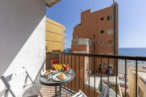 a plate of food on a table on a balcony at AlmeriaSuite Las Caracolas Beach in Almería