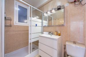 a bathroom with a toilet sink and a shower at AlmeriaSuite Las Caracolas Beach in Almería +16 photos
