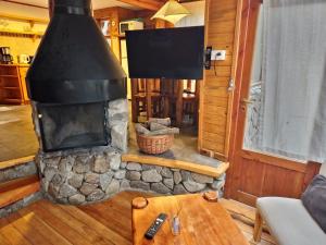 a stone fireplace in a living room with a table at El Remanso - Arrayan Cabin, Bahía Manzano in Villa La Angostura