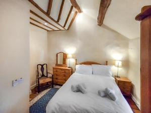 a bedroom with a large white bed with two pillows at Lobstone Cottage in Rosthwaite