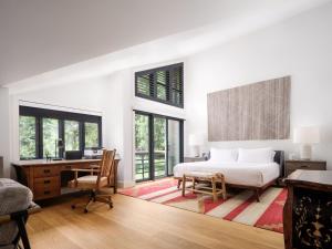 a bedroom with a bed and a desk and windows at RMR: Tram Tower 5 Condo in Teton Village in Teton Village