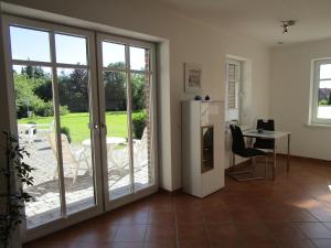 cocina con puertas correderas de cristal y mesa con sillas en Wohnung im Bungalow, en Fehmarn