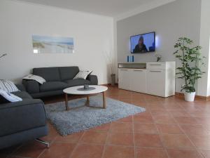 una sala de estar con un sofá y una mesa en Wohnung im Bungalow, en Fehmarn
