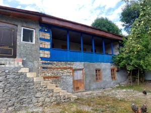ein altes Steinhaus mit blauer Farbe darauf in der Unterkunft Sulut Guest House in İsmayıllı