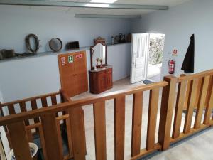 a room with a wooden staircase and a door at Quintinha dos Emigrantes in Cujó