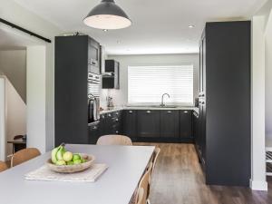 a kitchen with a table with a bowl of fruit on it at Cae Garw - Uk47587 in Caernarfon