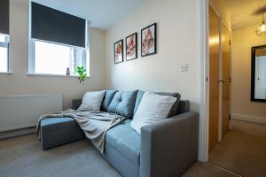 a living room with a blue couch and a window at 1-Bed Apartment in Bournemouth centre in Bournemouth