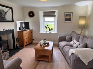 a living room with a couch and a table at Williamsfield Cottage in Holywood