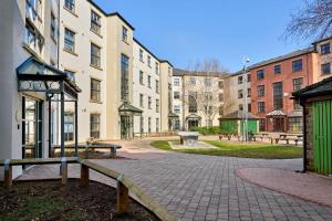 a group of buildings with benches in a park at For Students Only - Snow Island in Huddersfield in Huddersfield
