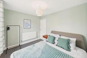 Schlafzimmer mit einem Bett mit grünen und weißen Kissen in der Unterkunft Host & Stay - The Coastal Retreat in Saltburn in Saltburn-by-the-Sea