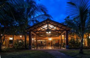 a building with tables and chairs in front of it at Popa Paradise Beach Resort in Buena Vista