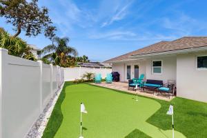 a backyard with green grass and a fence with golf clubs at Terrapin Station in Ormond Beach