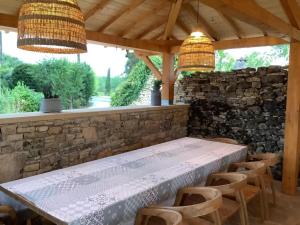 a dining room with a stone wall and a table and chairs at Gîte en Périgord avec piscine privée, animaux acceptés - FR-1-616-494 in Florimont-Gaumiers