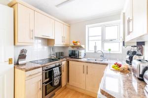 a kitchen with white cabinets and a counter top at Panoramic Sea View 2 bedroom Sleeps 6-Free Parking in Bournemouth