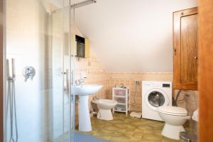 a bathroom with a toilet sink and a washing machine at Appartamento Villanova in Villanova Strisaili