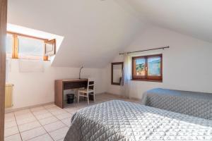 a bedroom with a bed and a desk and a table at Appartamento Villanova in Villanova Strisaili
