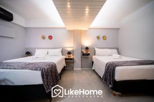 two beds in a hotel room with white walls at Royal Flat in João Pessoa +30 photos
