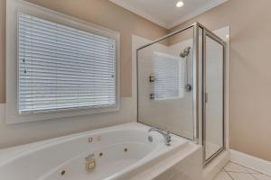 a bathroom with a tub and a shower and a window at The Pelican in Carolina Beach +34 photos