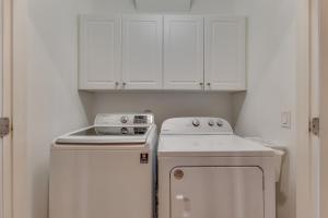 a small kitchen with white cabinets and a stove at The Pelican in Carolina Beach