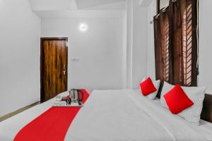 a bedroom with a bed with red pillows and a red blanket at Hotel O Star Stay Guest house opposite Kendriya Bhawan in Lucknow +23 photos