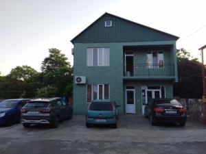 una casa verde con macchine parcheggiate di fronte di Natalia - Bagrationi St # 42 a Kobuleti
