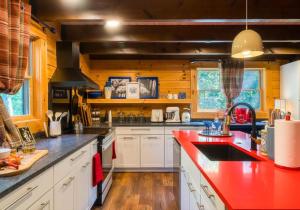McGaheysvilleにあるChic Designer Log Cabin Hot Tub Pool Tabledecksのキッチン(白いキャビネット、赤いカウンタートップ付)