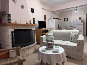 a living room with a couch and a fireplace at Mina Apartments in Poros